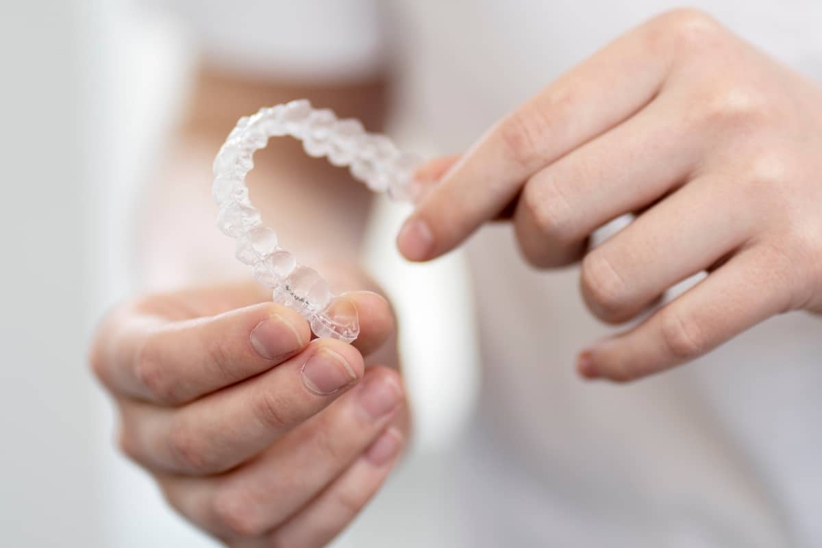 dental patients holding Invisalign aligners