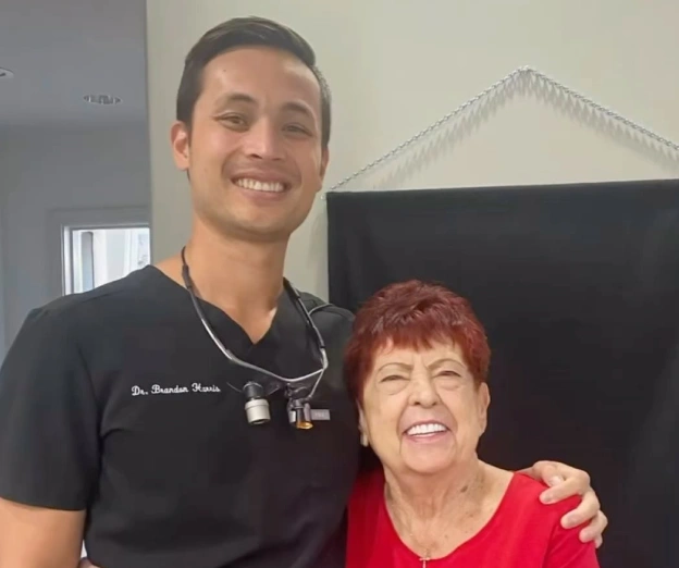 Dentist in scrubs posing with senior patient for general dentistry at BCR Dentistry