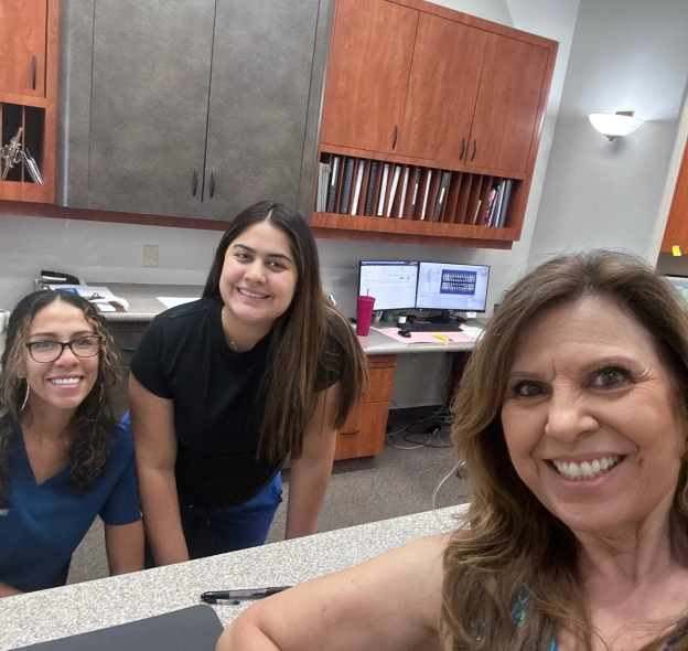 Front desk team smiling with patient discussing insurance and financing at BCR Dentistry
