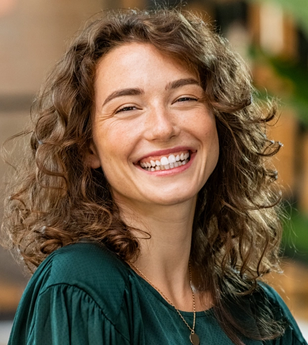 A smiling woman with bright, white teeth next to web copy describing professional teeth whitening services at Biltmore Cosmetic & Restorative Dentistry in Phoenix.